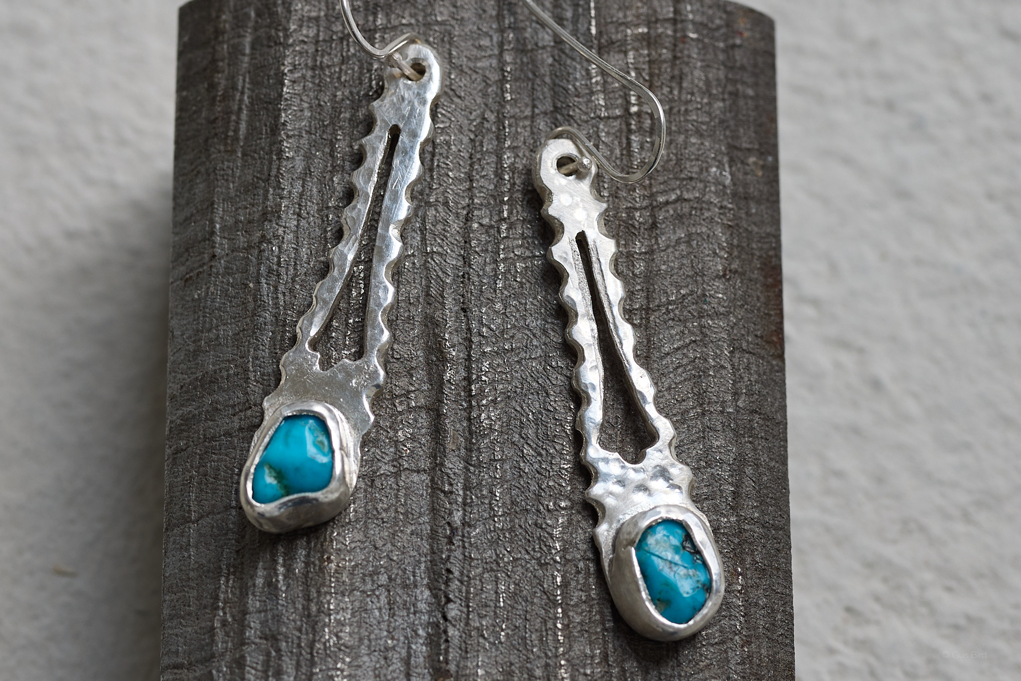 Earrings on raw cut titanium block.