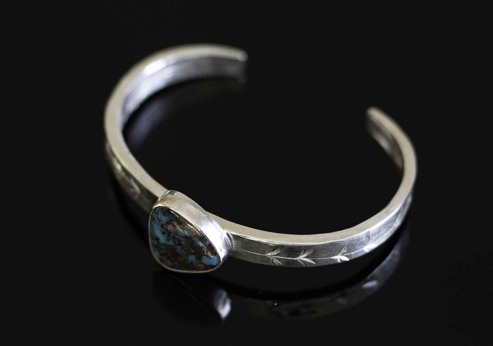 Bisbee cuff on black reflective table. 