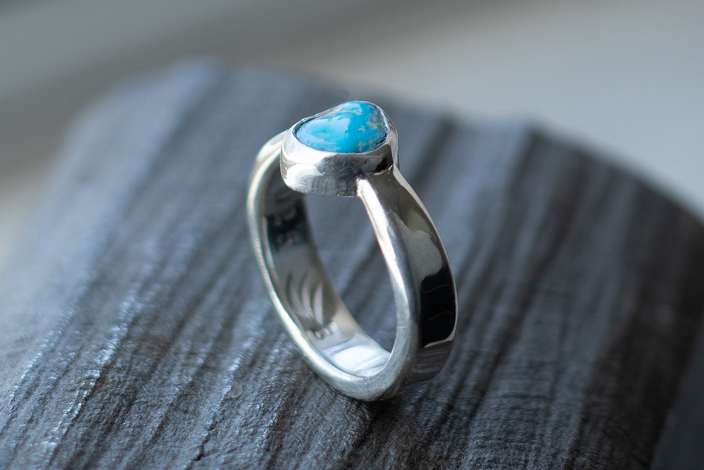 Turquoise ring on titanium block.